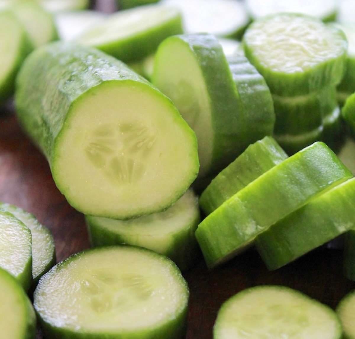 Sliced cucumber on cutting board.