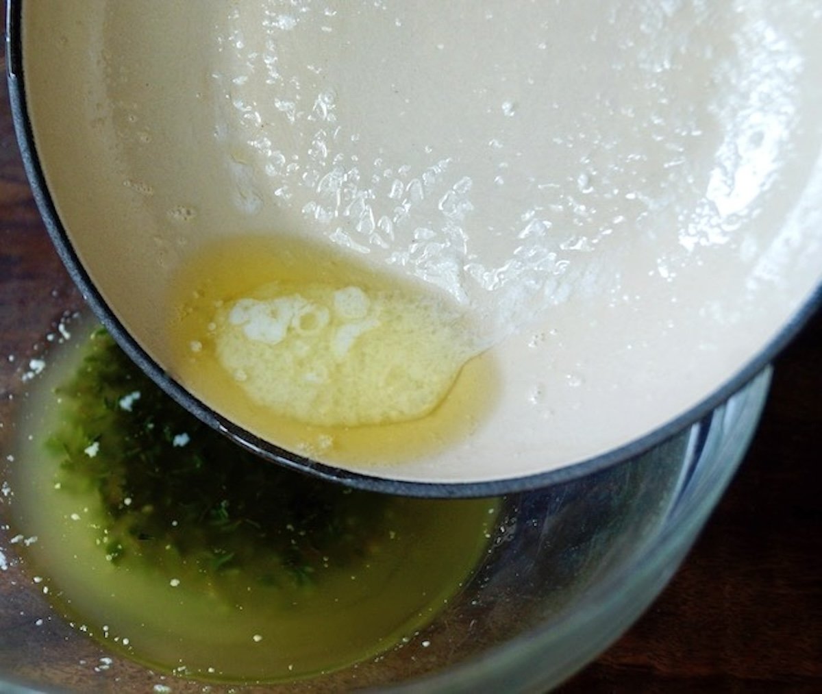 Clarified butter being poured out of a small pan.