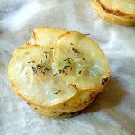 One mini pommes anna on parchment paper.