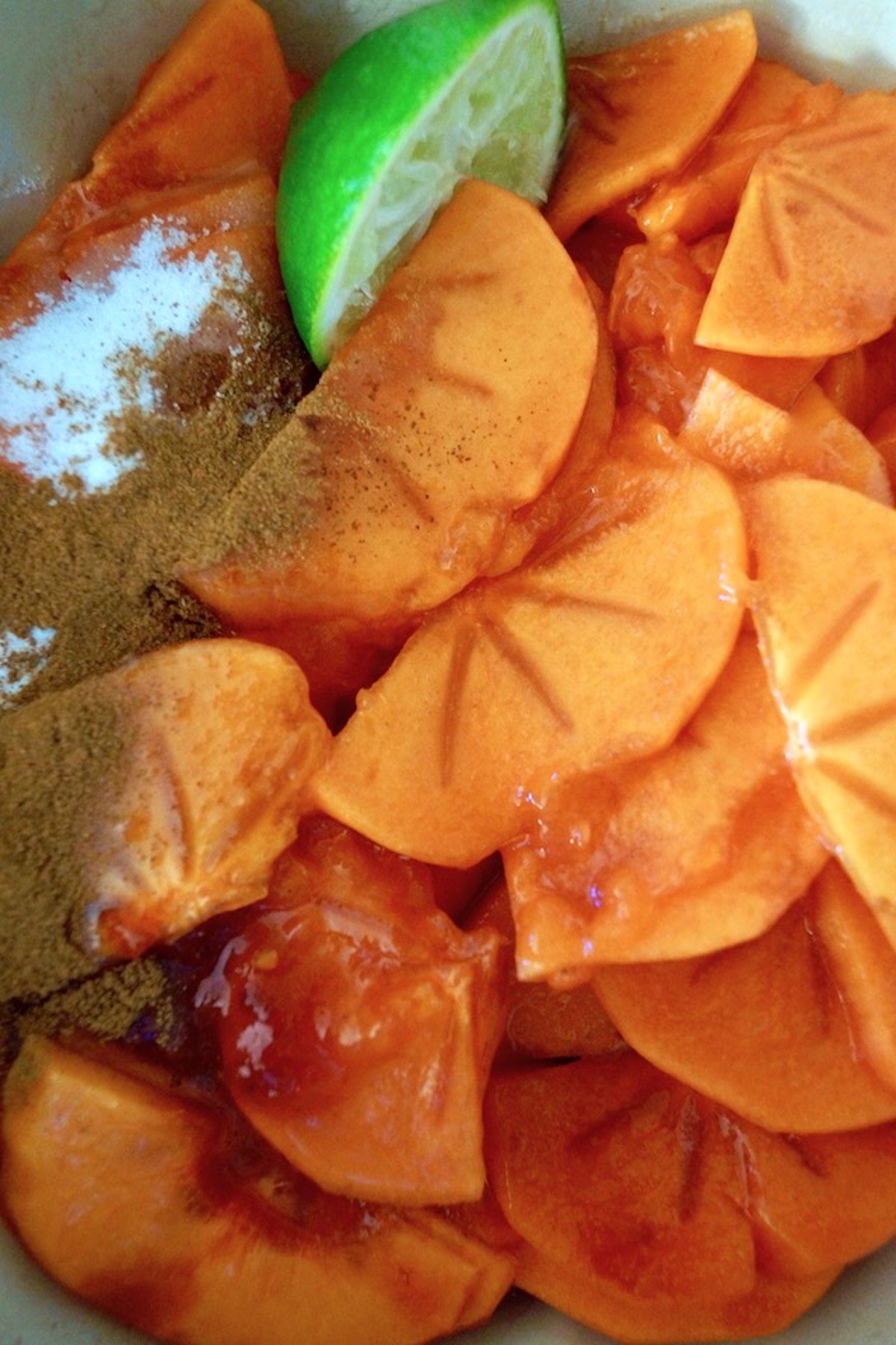 Bowl of persimmon slices and spices.