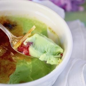 Close up of a bite of Coconut-Pandan Creme Brulee with a raspberry.