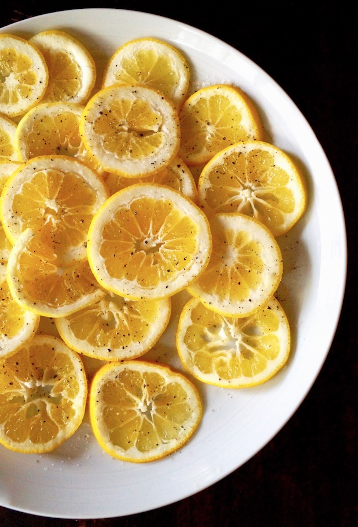 Fried-Lemon-Caesar-salad-Recipe Large white plate full of lemon slices.