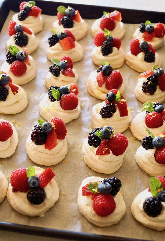 A dozen Mini Lemon Berry Pavlovas on parchment paper