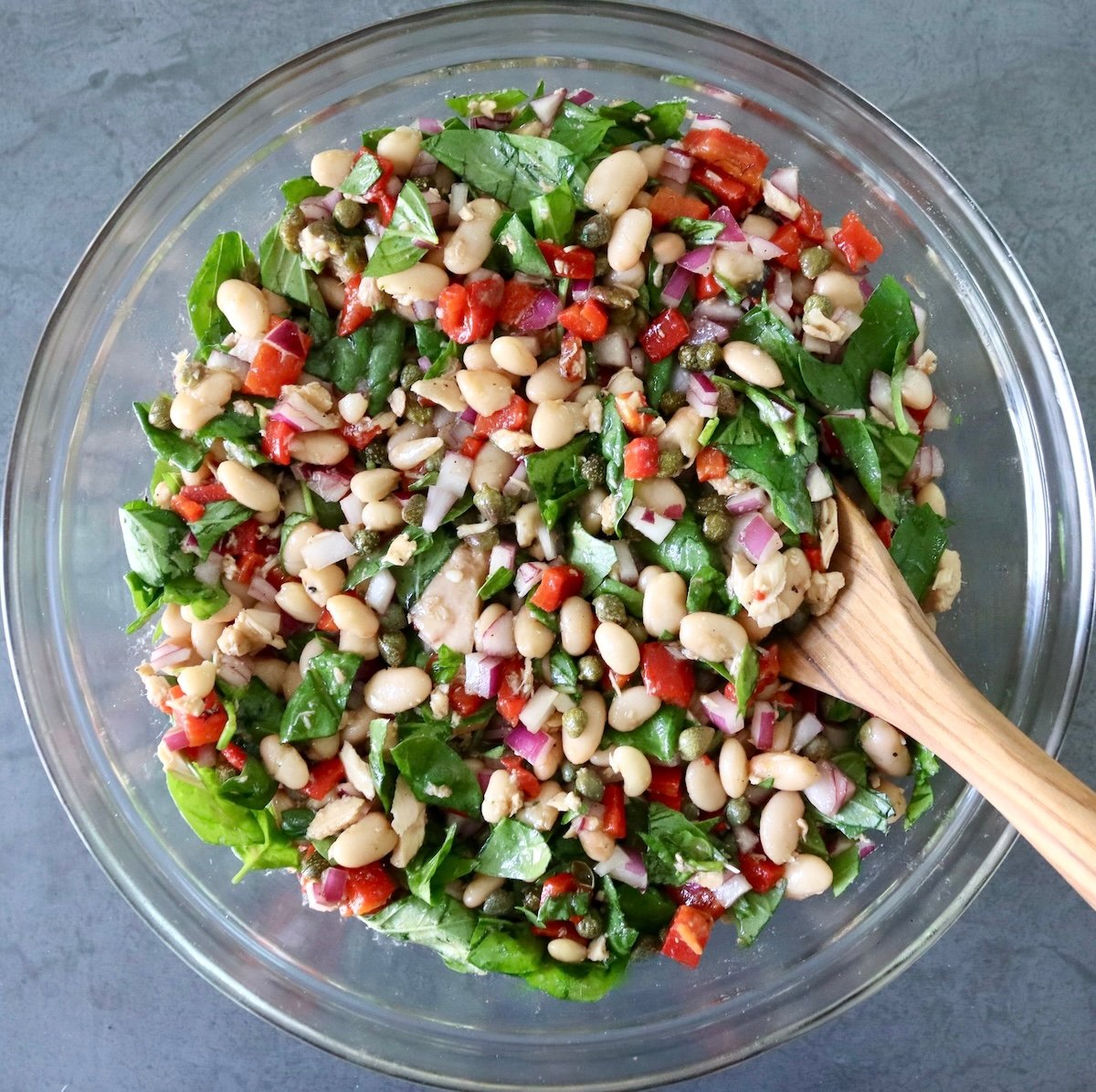 Mixed cannellini bean tuna salad in a glass bowl.