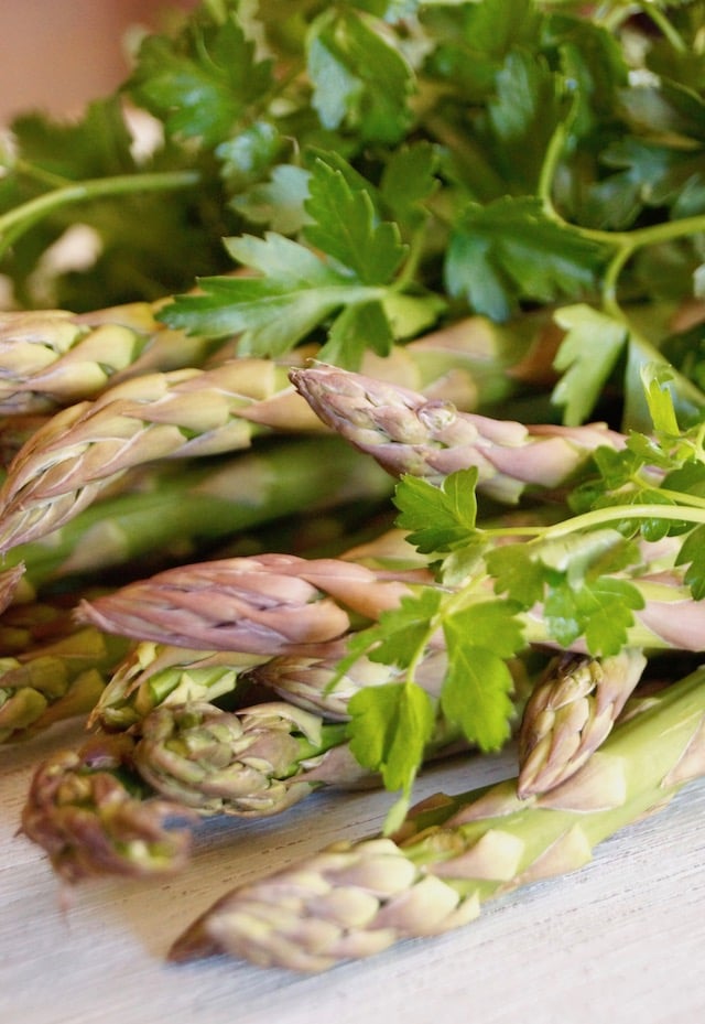 pile of fresh, raw asparagus and parsley