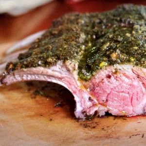 whole Pistachio Mint Crusted Aussie Rack of Lamb on a cutting board