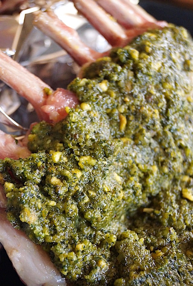 Raw rack of lamb with pistachio mint pesto spread over it