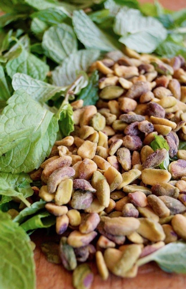 Fresh mint and toasted pistachio nuts on cutting board