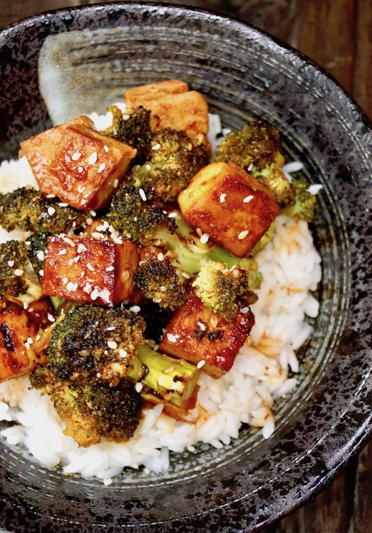 Top view of Sriracha Honey Tofu Broccoli in a black with white rice.