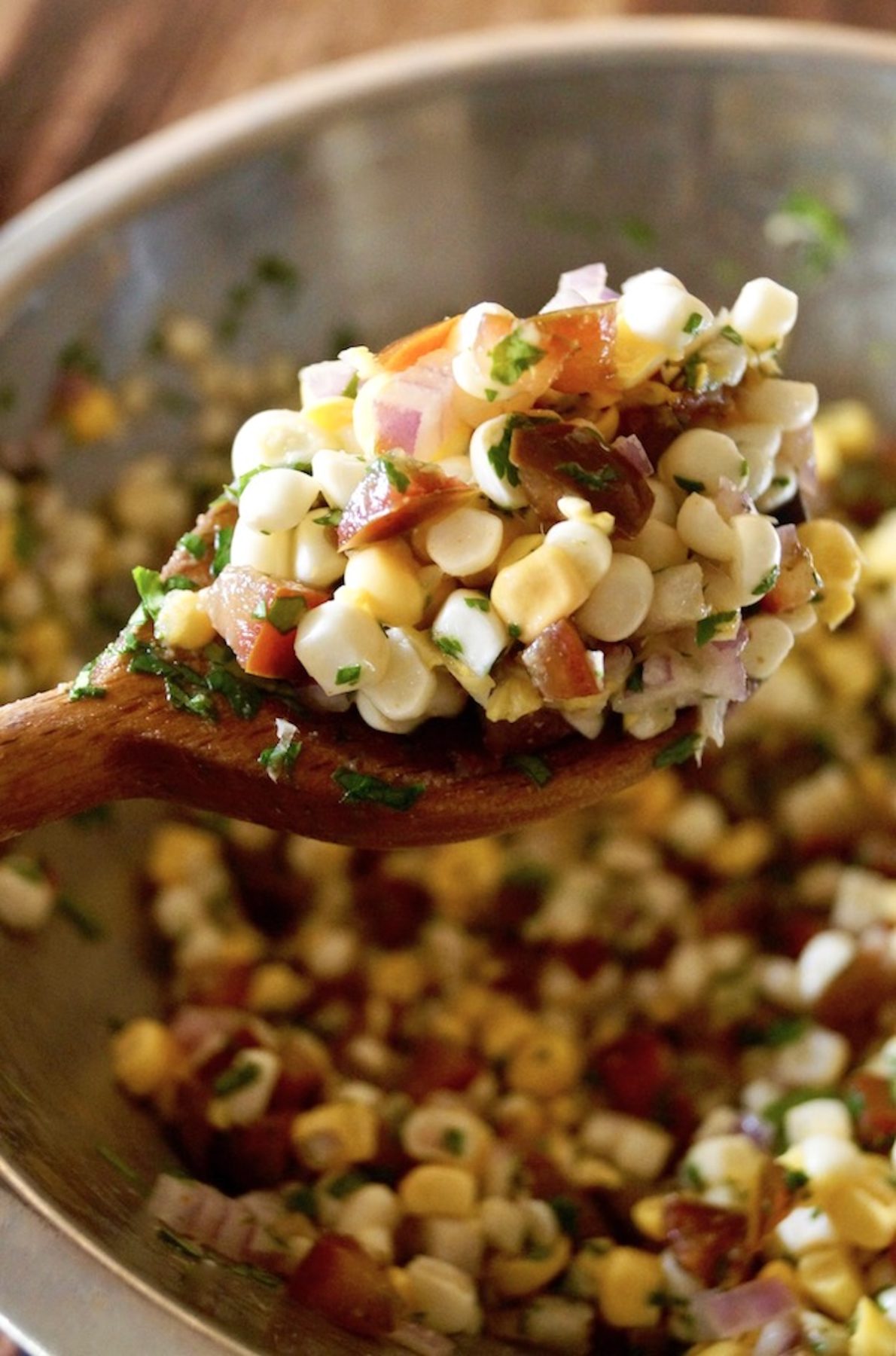 Sheet-Pan-Chipotle-Chicken-with-Corn-Salsa Big wooden spoonful of corn salsa.