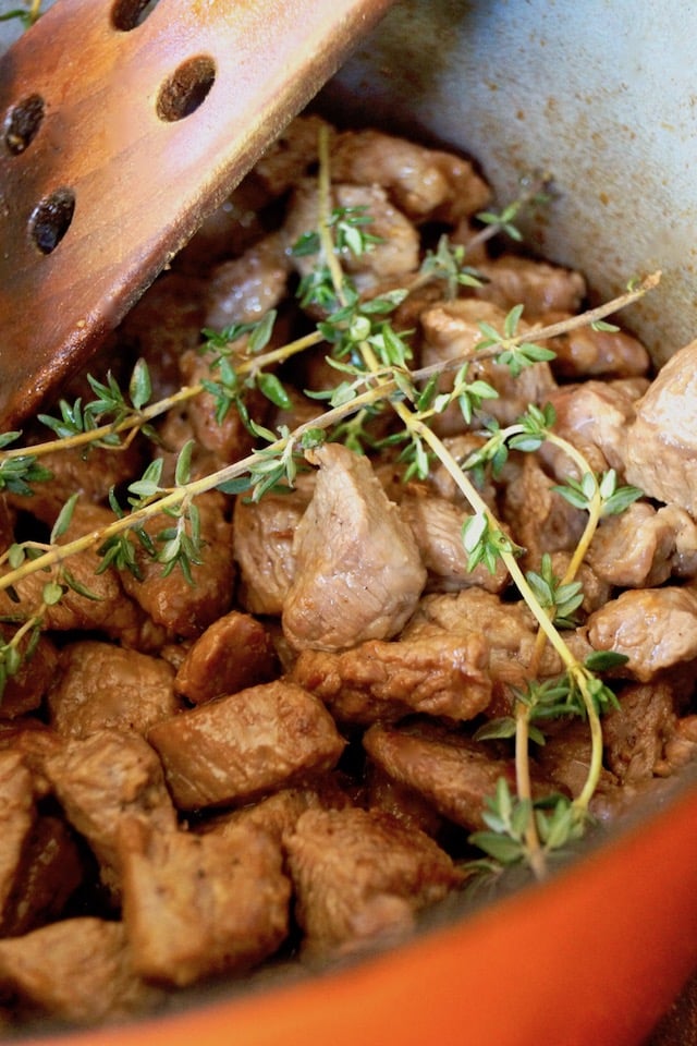 lamb chunks in pot with fresh thyem