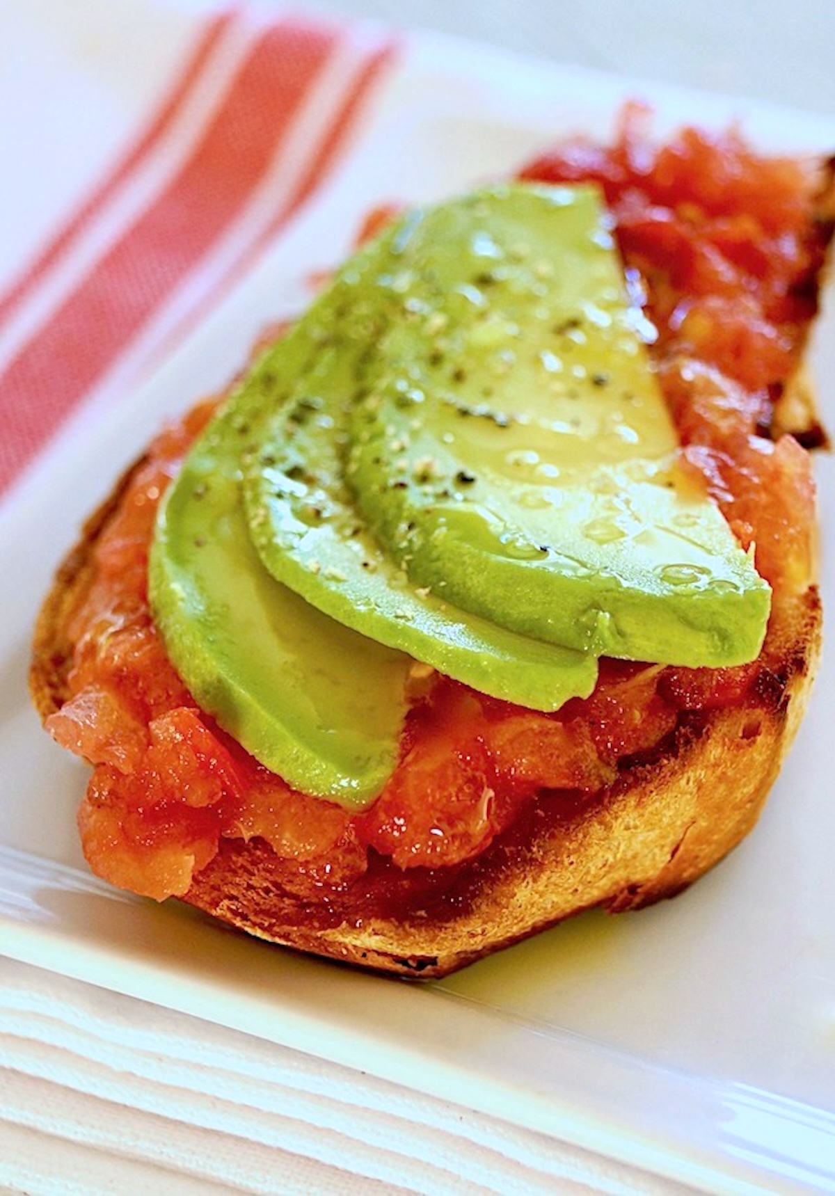 Sweet-Breakfast-Grated-Tomatoes-with-Olive-Oil Rustic bread with grated tomatoes and sliced avocado.