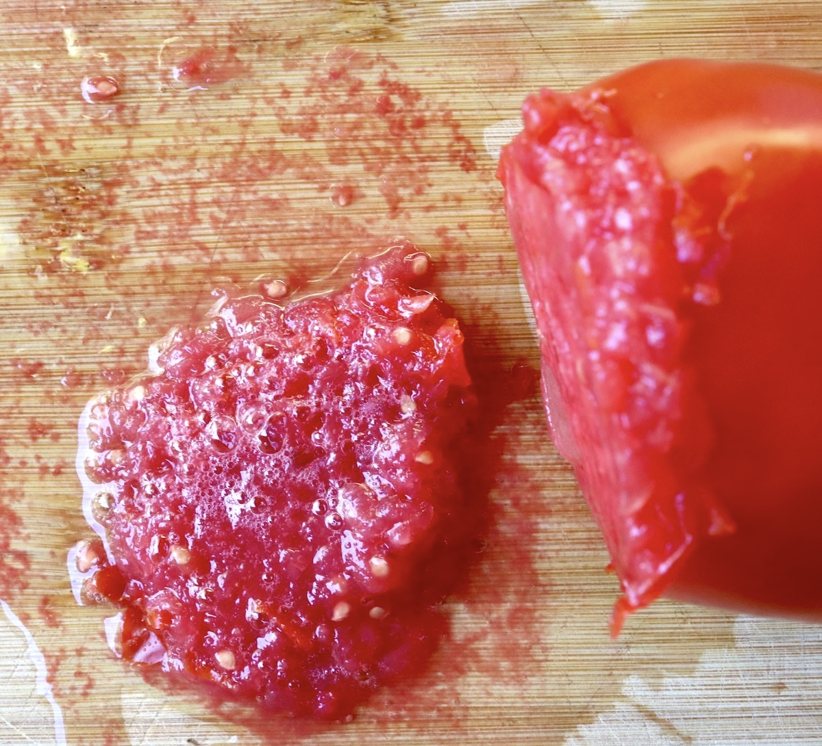 Sweet-Breakfast-Grated-Tomatoes-with-Olive-Oil Grated tomato with pulp on cutting board.