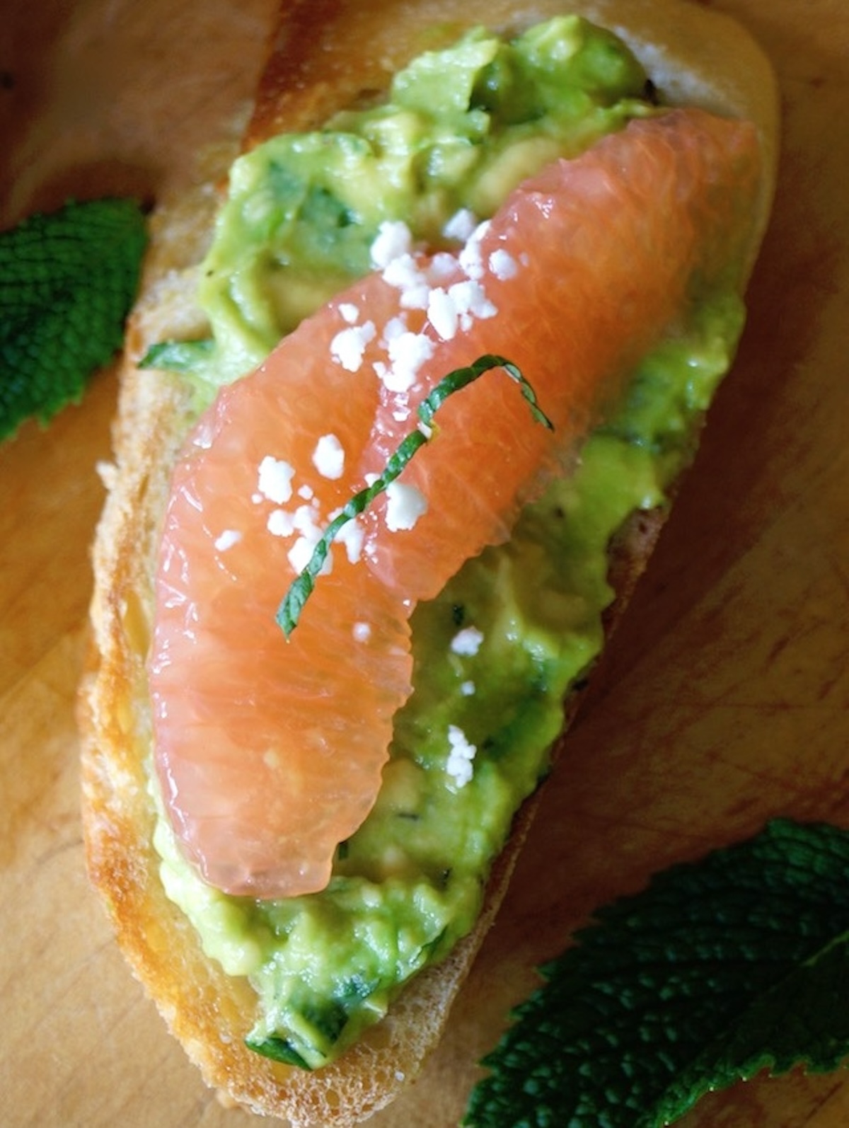 Avocado toast with a couple grapefruit slices on top, with a light Feta cheese sprinkling.