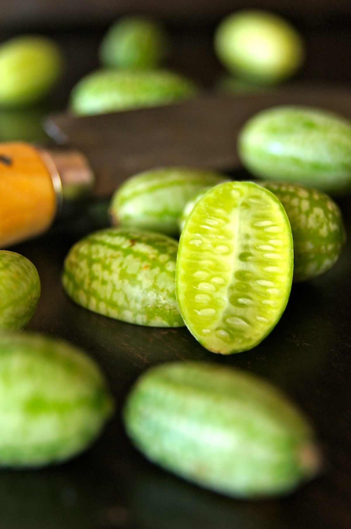 Ponzu-Marinated-Cucamelon-Recipe Several cucamelons with one sliced in half.