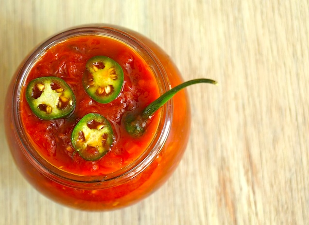 Spicy Serrano-Tomato Preserves in a jar, viewed from the top.