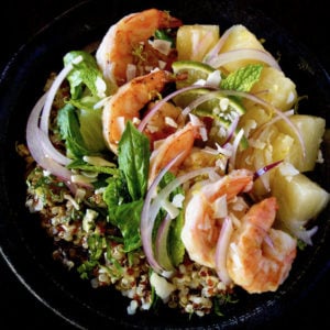 Tropical Quinoa Salad Bowl with Shrimp in a dark ceramic bowl