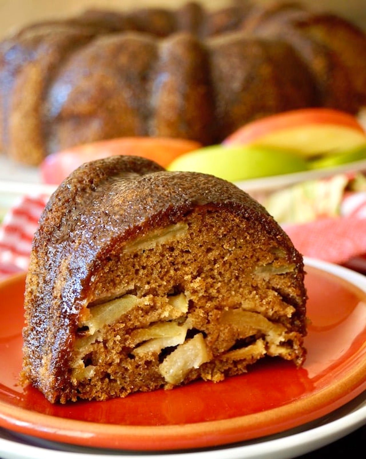 Close up of a slice of Chai Apple Bundt Cake on a red plate.