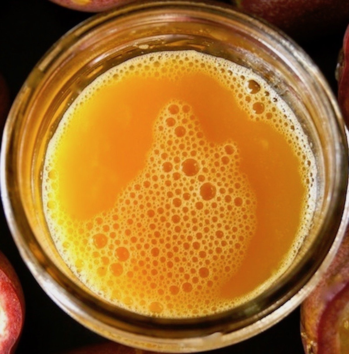 Top view of bowl of jar of orange passion fruit juice.