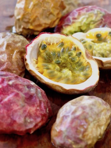 Many passion fruit skins and one facing up with pulp still inside.
