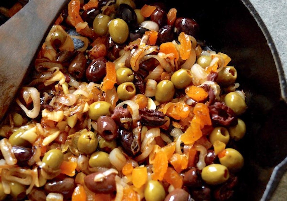 Mix of shallots, olives and apricots in cast iron skillet