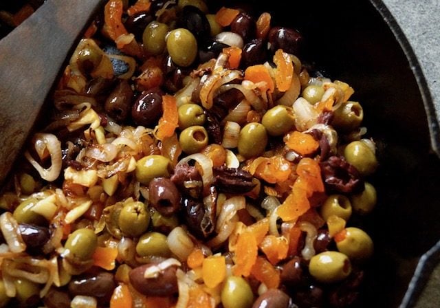 Mix of shallots, olives and apricots in cast iron skillet