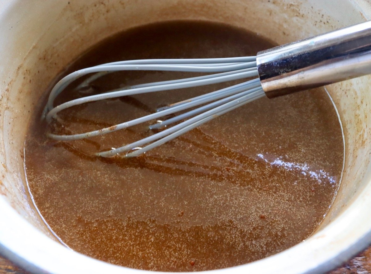 Chai spice glaze in a  small suace pan with a whisk.