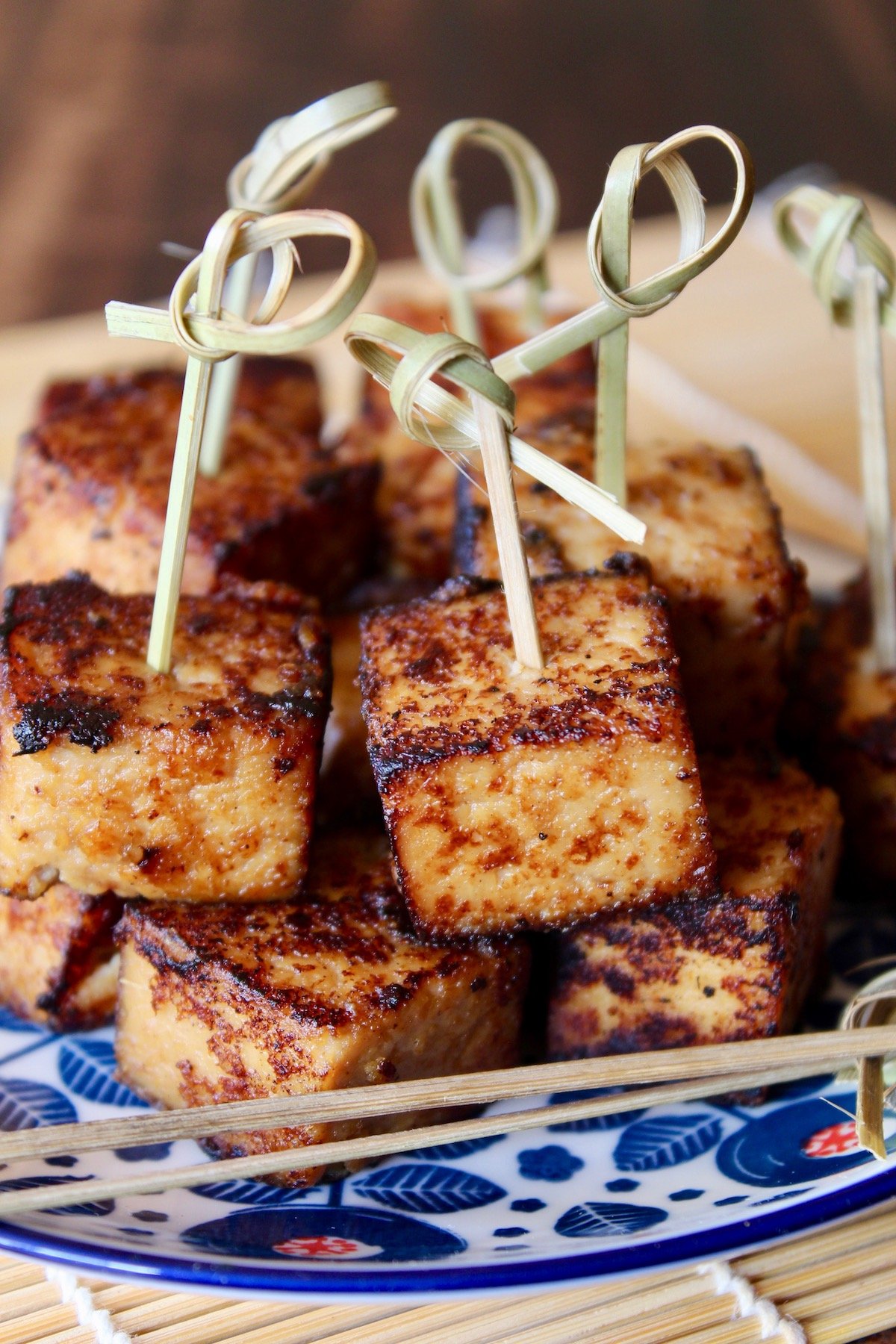 Miso marinated tofu on blue and white plate with toothpicks