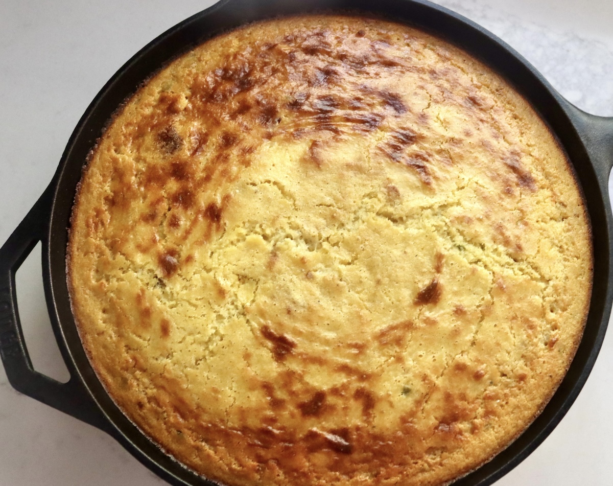 Golden bacon jalapeno cornbread baked in a cast iron skillet