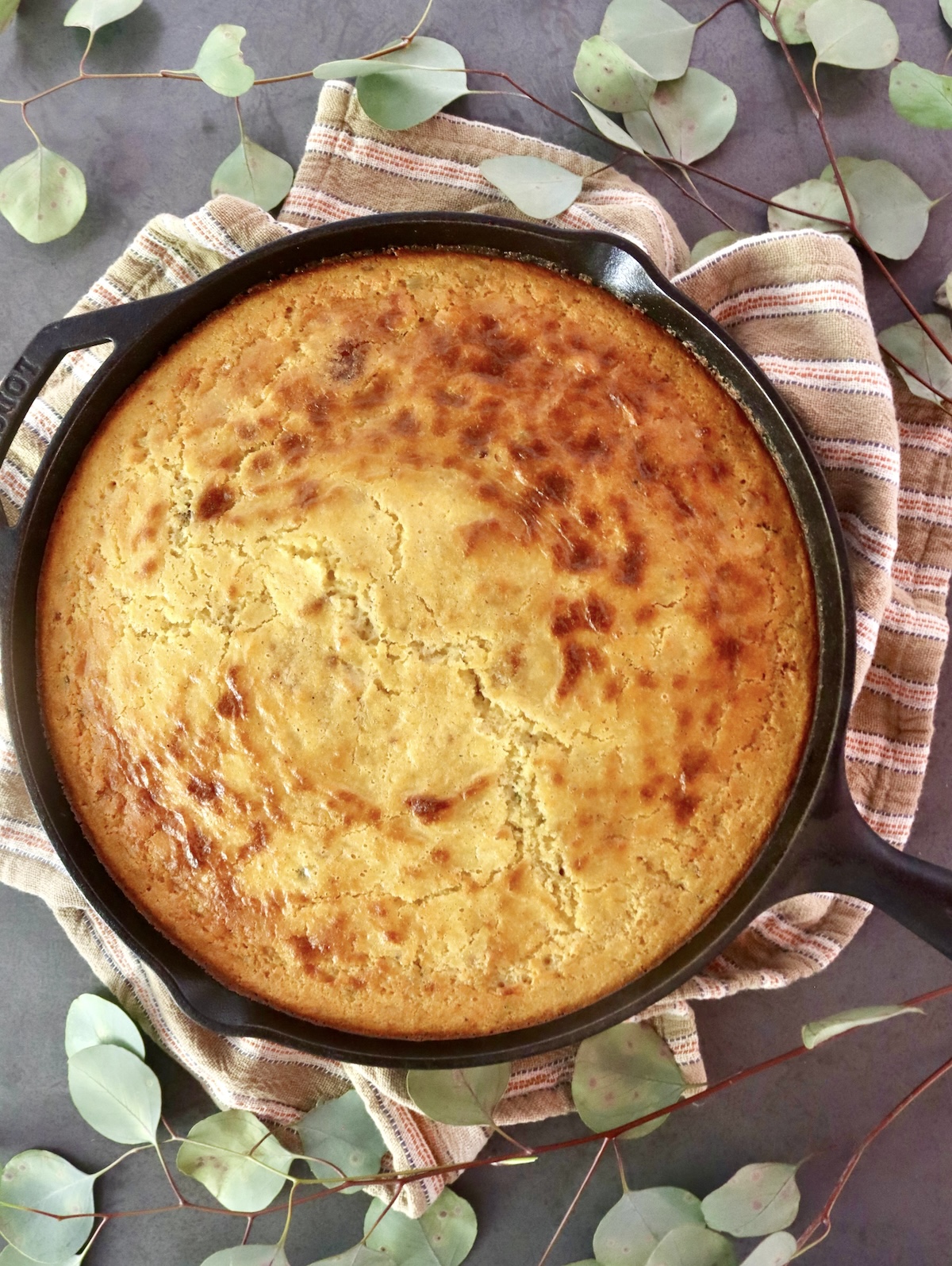 Top view of a golden cornbread baked in a large cast iron skillet.