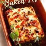 Close up of Baked Feta with Olives and Roasted Peppers with fresh oregano in a terra cotta dish with title text