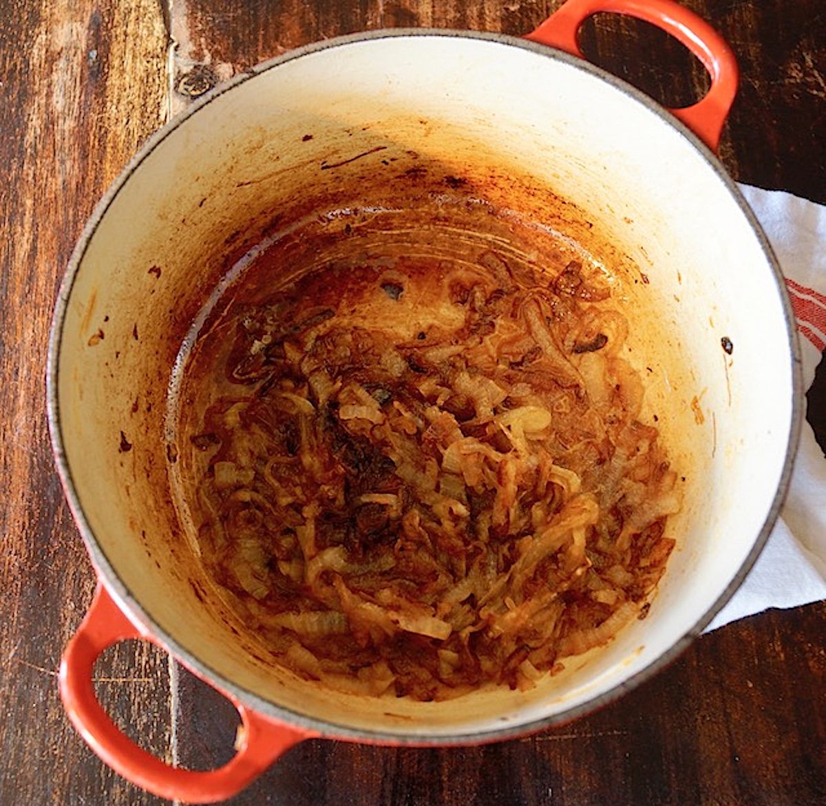 Bottom of a Dutch oven coated with deep brown caramelized onion.