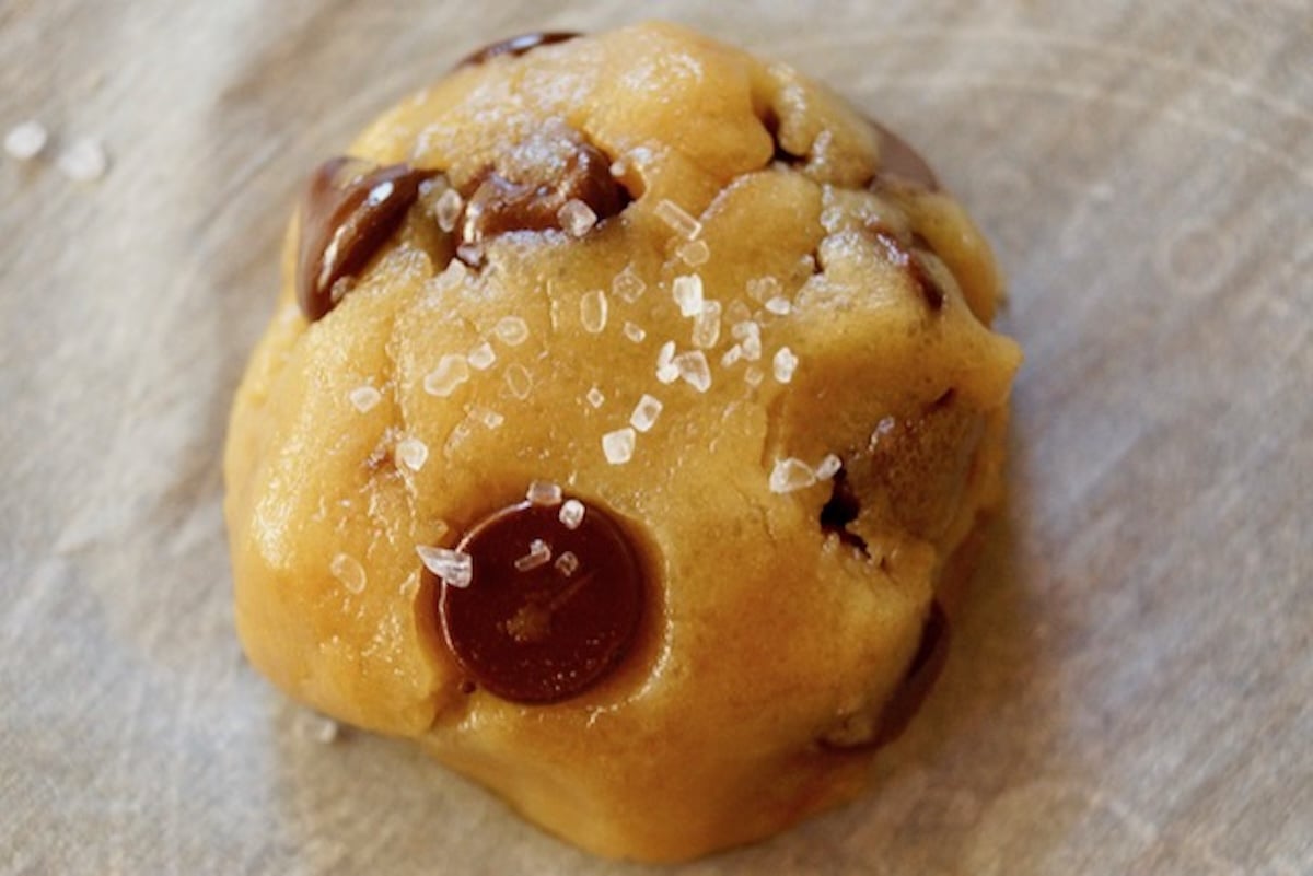 Ball of olive oil chocolate chip cookie dough with salt on top.