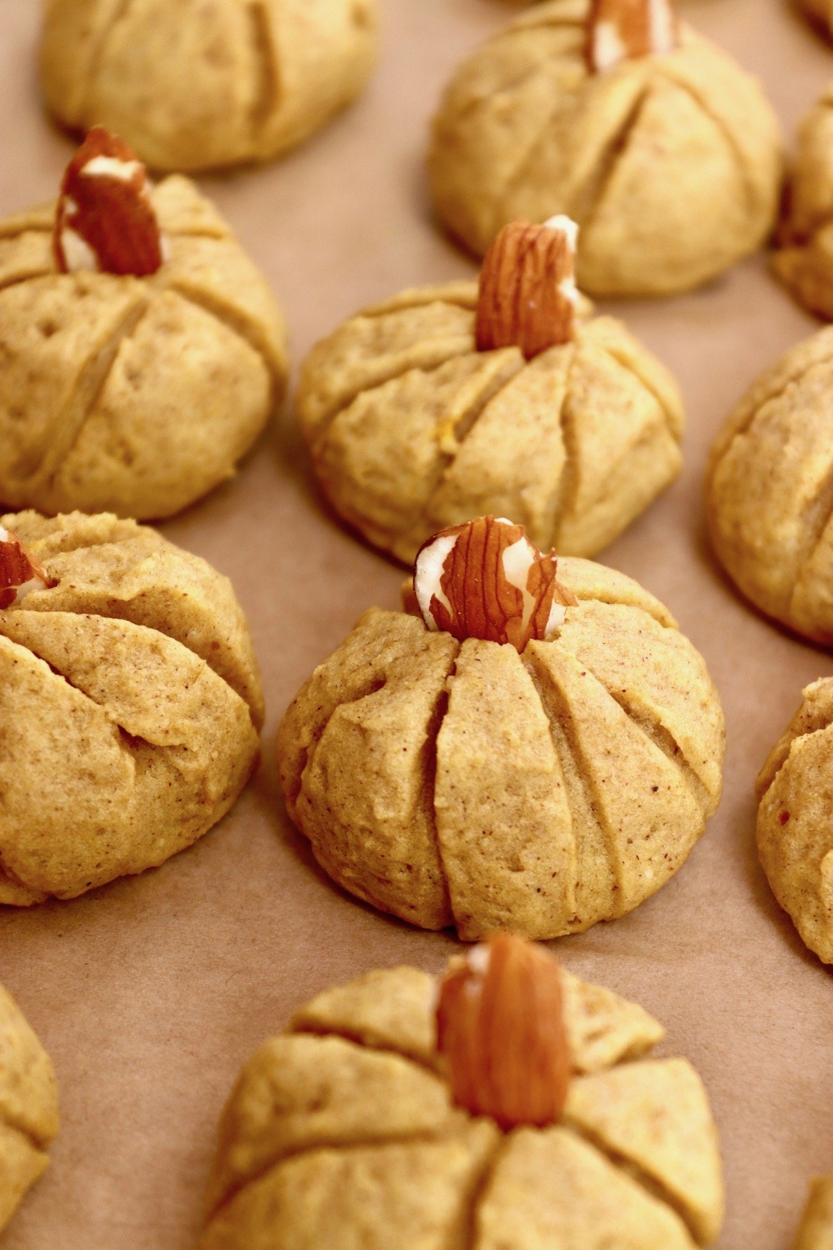 Close up of a few baked Pumpkin Almond Cookies on parchment paper.
