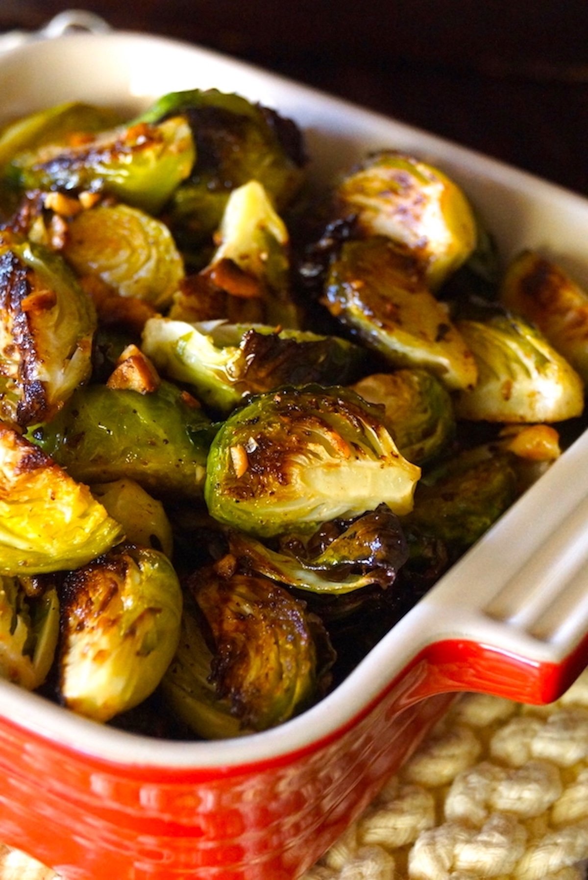 Super browned quartered brussels sprouts in a red baking dish.