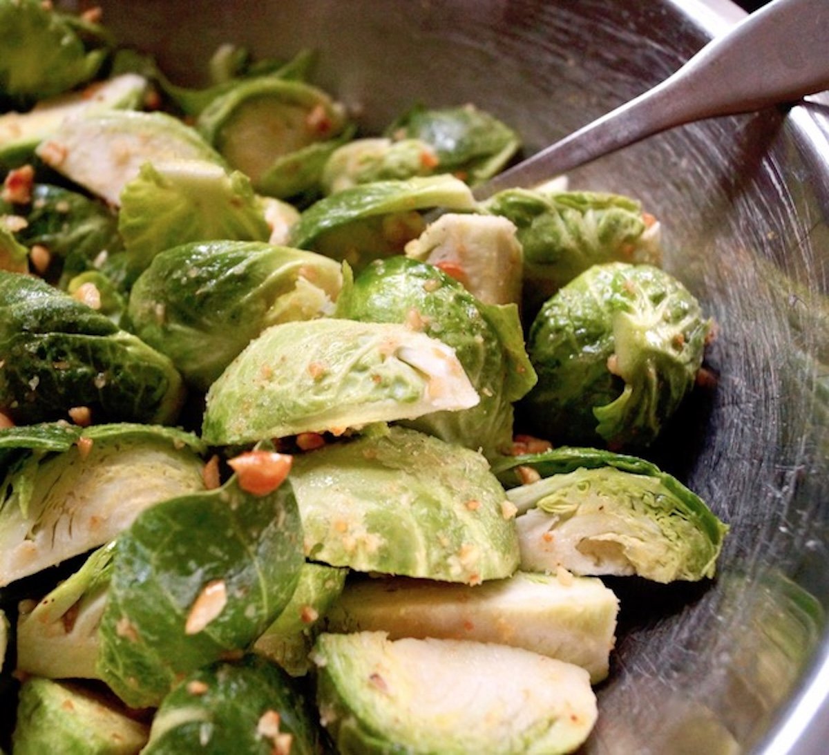 Quartered brussels sprouts mixed with brown butter with chopped hazelnuts.