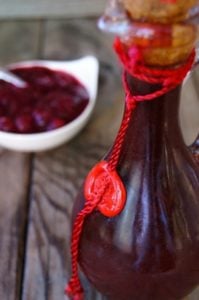 Balsamic Cranberry Dressing in a tall bottle with a cork.