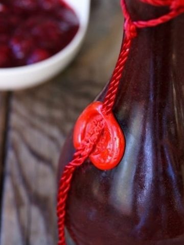 Cranberry salad dressing in a tall jar with a red string.