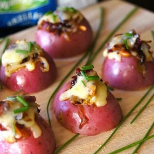 Tiny red potatoes with cranberries in the center on cutting board