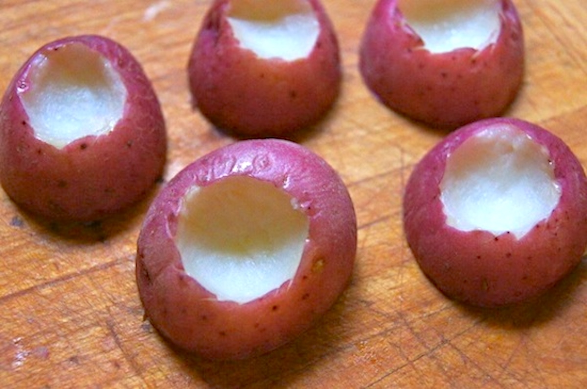 Mini-Red-Potato-Appetizer-with-Cranberries Several small red potatoes, halved, with a tiny hole taken out of the tops.