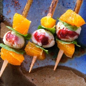 three tiny orange and mozzarella kebabs with mint