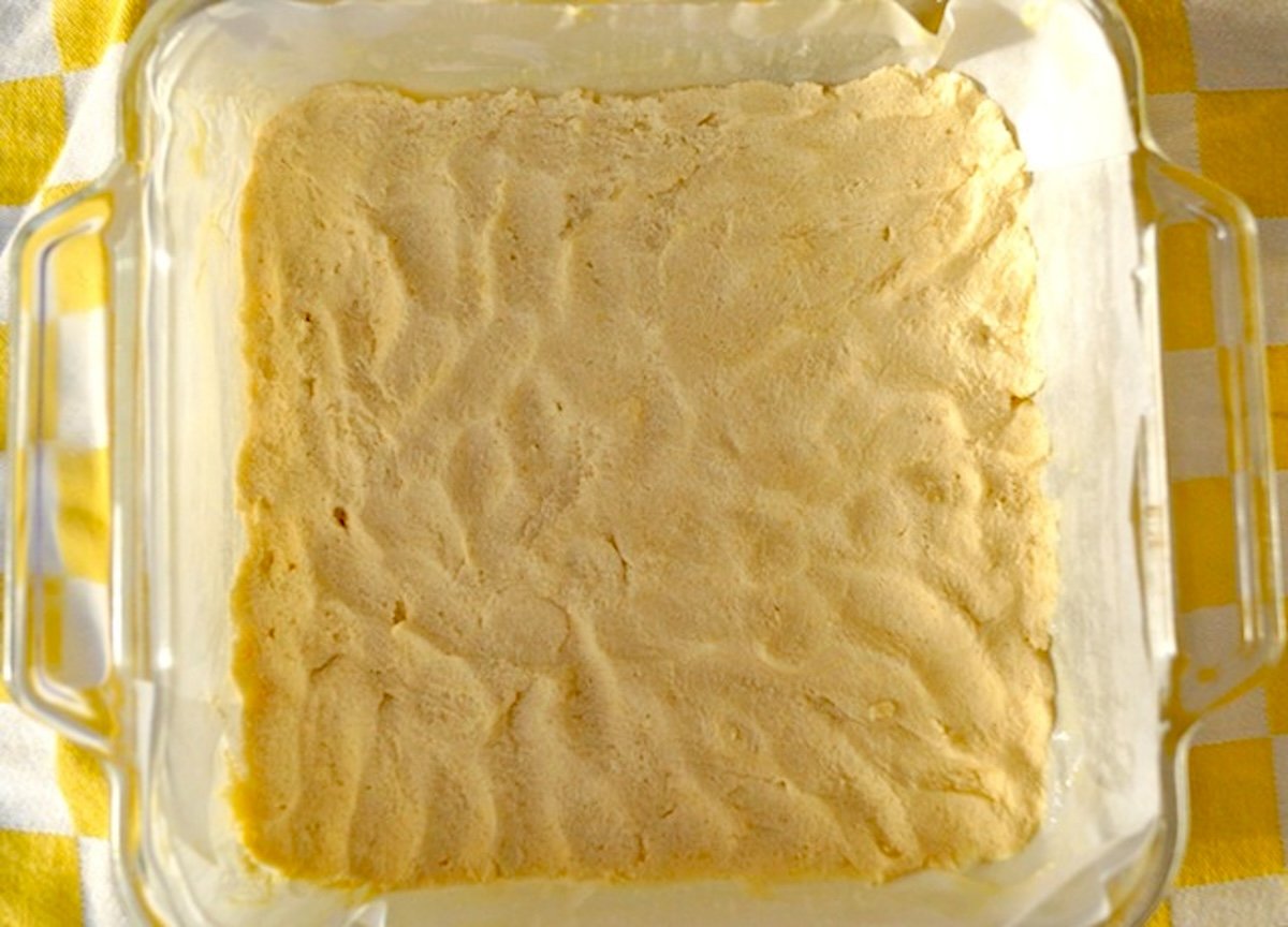Raw coconut flour crust for lemon bars in an 8 x 8-inch baking pan.