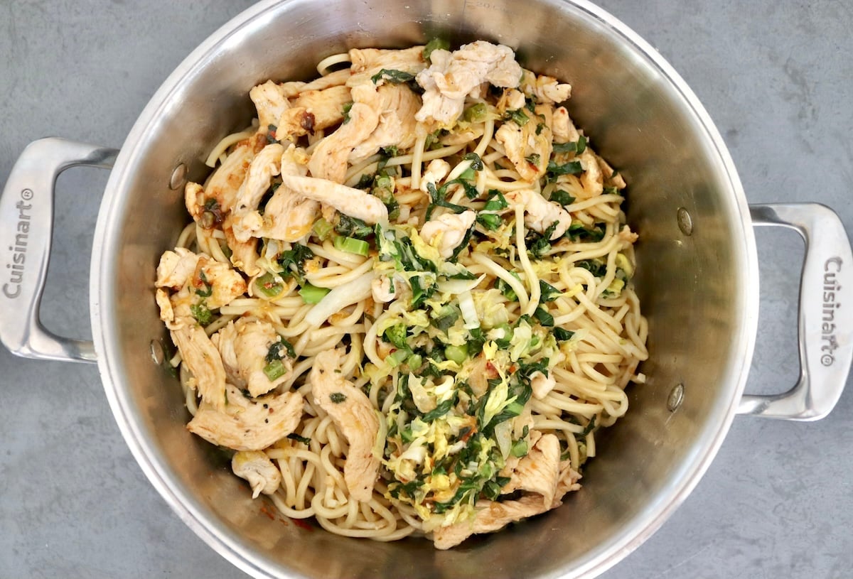 Chinese-Longevity-Noodles-Recipe Large pot with cooked Chinese noodles, cabbage, Gai Lan and cooked chicken pieces - not mixed.