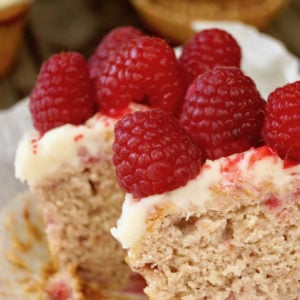 Raspberry cupcake cut in half with raspberries on top