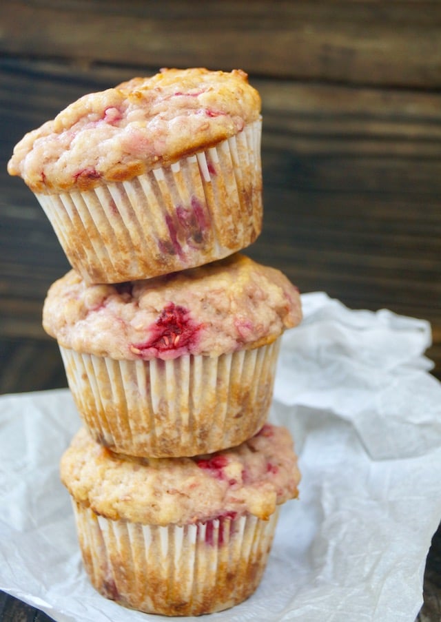 3 stacked Fresh Raspberry Muffins on parchment paper