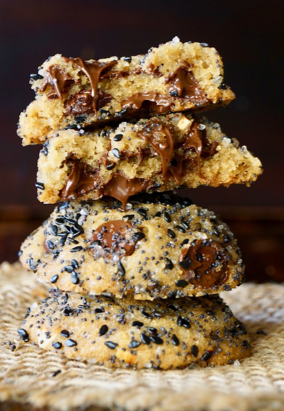 Stack of a few Everything Bagel Cookies with one broken in half a and melted chocolate chip showing.