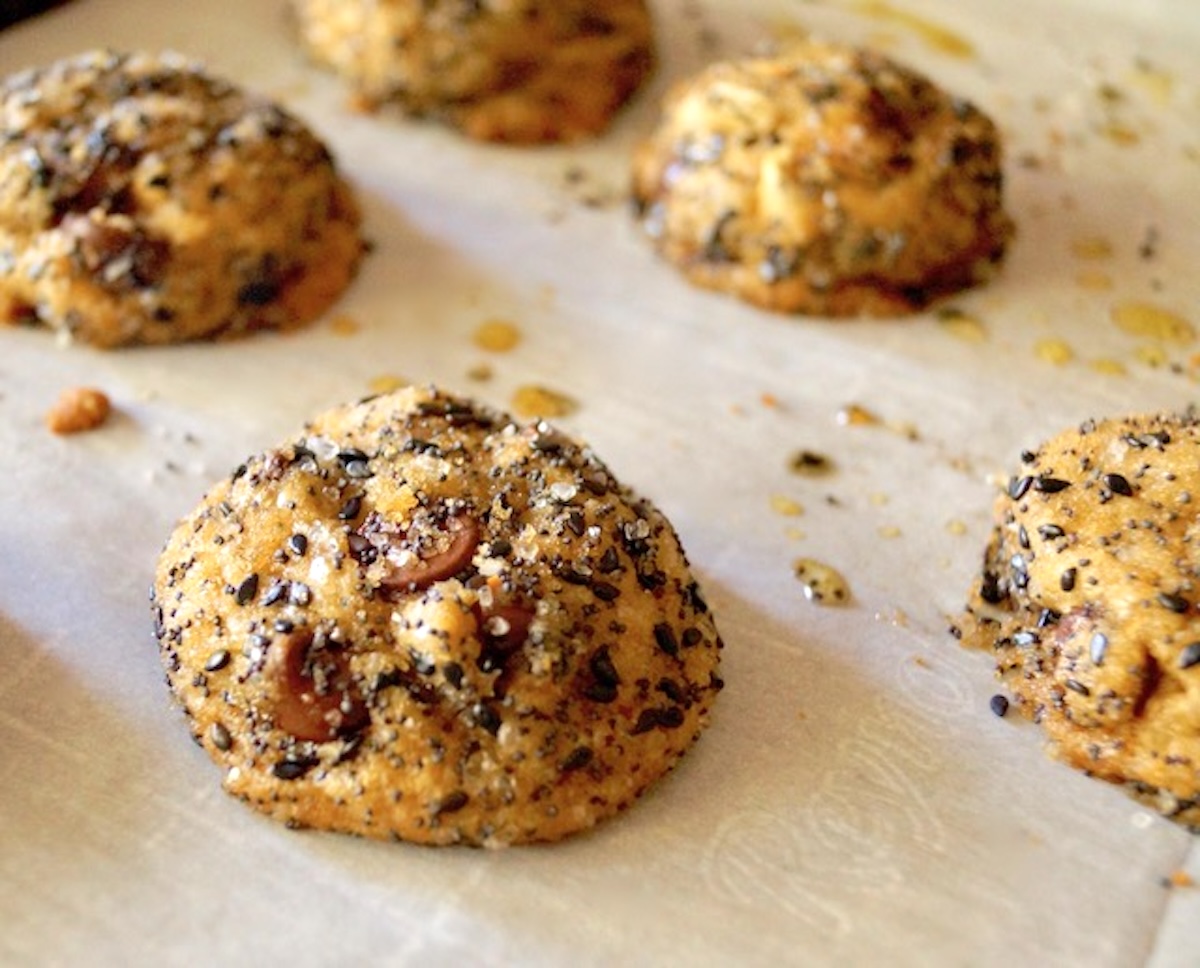 A few baked Everything Cookies on a parchment-lined baking sheet.