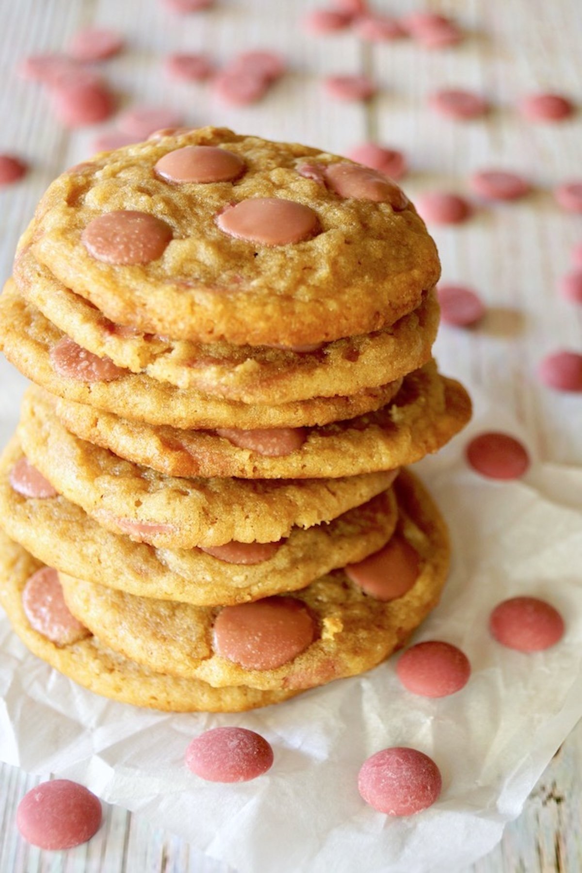 Tall stack of cookies made with pink chocolate chips.