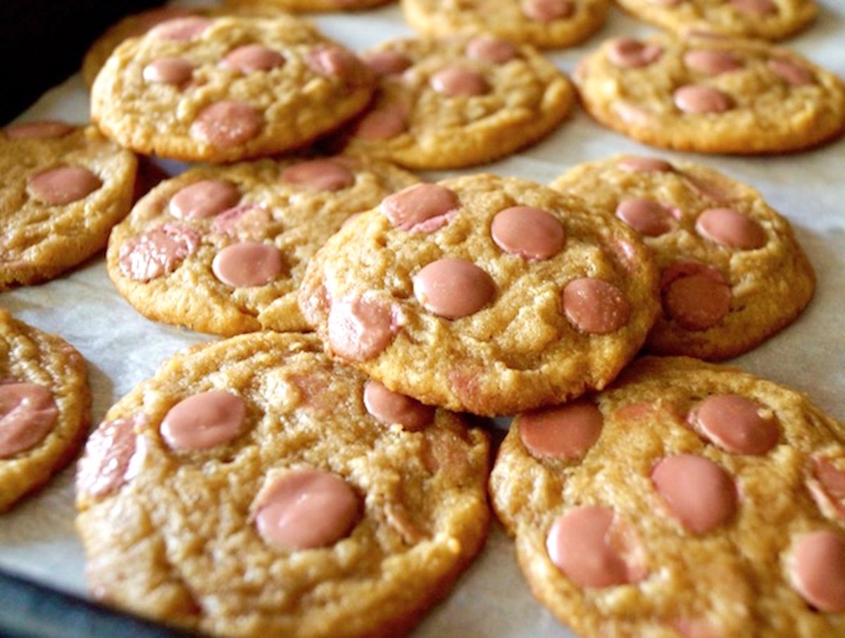 A couple of layers baked of Ruby chocolate chip cookies on parchment paper.