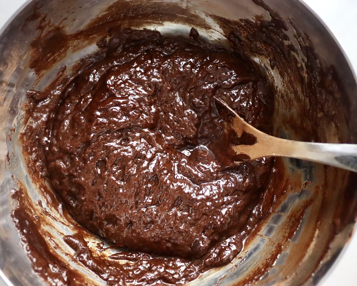 Flourless Chocolate-Cake-with-KahlĂșa-and-Espresso Batter for chocolate espresso flourless cakes in a stainless steel bowl with a spoon.